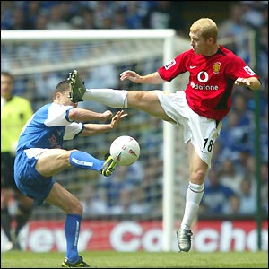 Paul Scholes and Dennis Wise fight a running battle for midfield supremacy as Millwall look to stifle their illustrious opponents 