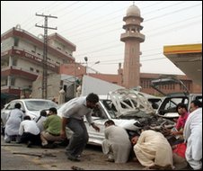 Pakistani media take cover outside a mosque in Lahore, 28 May