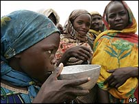 A girl drinks water in Darfur refugee camp
