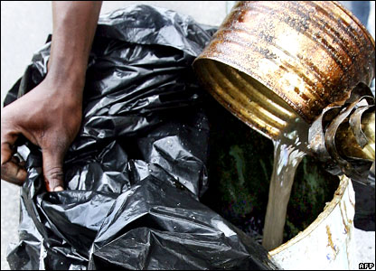 An Ivorian man pours toxic waste into a tank 