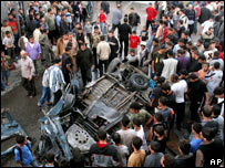 Palestinians surround the wreckage of a van hit by an Israeli air strike
