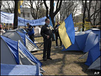 A supporter of Mr Yanukovych holds a national flag in a tent camp in Kiev