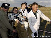 Space tourist Charles Simonyi is carried in his chair to a medical tent after landing, 21 April 2007
