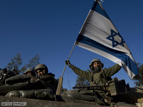 An Israeli soldier holds up an Israeli flag after leaving Gaza on Sunday.