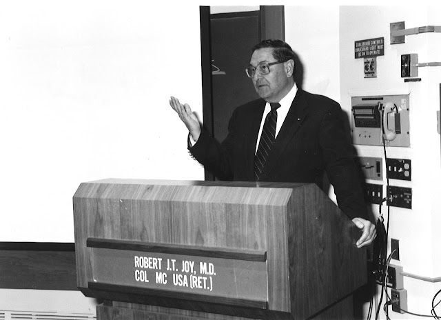 Dr. Robert J.T. Joy speaks at a podium.