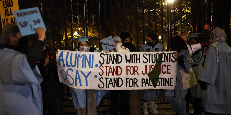 NEW YORK, NEW YORK - NOVEMBER 20: People gather to protest the banning of Students for Justice in Palestine (SJP) and Jewish Voice for Peace (JVP) at Columbia University on November 20, 2023 in New York City. Students, alumni of both schools, some dressed in caps and gowns, and supporters held a "Denouncement Ceremony" and pledged not to donate money to the schools after the banning of the student groups for holding a nonviolent but unsanctioned protest demanding a ceasefire in Gaza. More than 20 progressive elected officials have sent a letter to the university calling for the reinstatement of the groups. Calls for a ceasefire in Gaza continue as the death toll from Israel’s invasion of Gaza has increased in the weeks since the October 7 Hamas attack. (Photo by Michael M. Santiago/Getty Images)