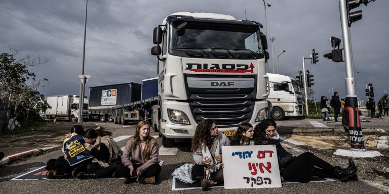 ASHDOD, ISRAEL - FEBRUARY 01: Some of Jewish protestors, belonged to 'Hill Youth' group, sit on the ground and in front of the trucks, trying to reach the port and block the passage of vehicles as they stage a demonstration to prevent humanitarian aid being sent to Gaza near the port in Ashdod, Israel on February 01, 2024. (Photo by Mostafa Alkharouf/Anadolu via Getty Images)