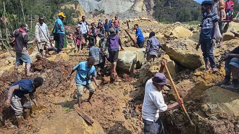 Villagers search through a landslide in Yambali, in the Highlands of Papua New Guinea.
