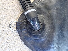 Corner of sidemount buoyancy compensator wing showing inflation hose attachment