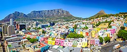 Bo-Kaap area of Cape Town with its distinctive pastel coloured houses in the foreground, with the city centre to the left and Table Mountain in the background