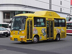 黄色い塗装の中型バスのボディーにサッカーに興じるキタロウなどが描かれている。
