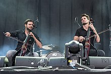 Two men playing cellos on a stage.