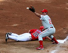 Thome with an outstretched glove about to catch a pickoff throw to first base; meanwhile, Terrmel Sledge dives back safely.