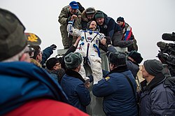 Scott Kelly being carried from the Soyuz TMA-18M spacecraft