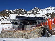Photographie de remontées mécaniques devant des pistes de ski.