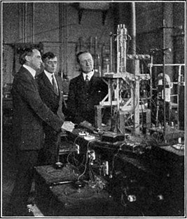 Whitney (left) and Langmuir (center) showing Guglielmo Marconi (left) a vacuum tube that G.E. produced for radio transmitters.