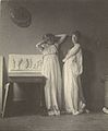„Dvi pozuotojos su klasikiniais drabužiais prie T. Ikinso skulptūros „Arkadija“, apie 1883 m.