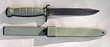 Glock field knife/bayonet and its scabbard. The upper crossguard is bent forward and can be used as a bottle opener.