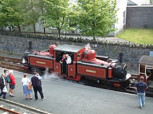 Red locomotive, with observers on a platform