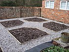 Parterre beds laid out ready for planting, with paths gravelled. One half of a symmetrical design flanking a path shown