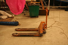 Pallet jack in lowered position, allowing it to be inserted under a load on a pallet