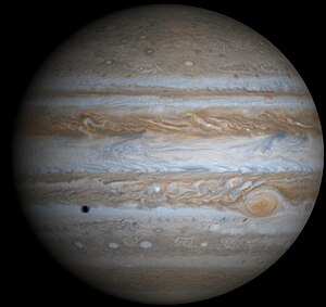 Jupiter in natürliche Farbe mit Schatte vum Mond Europa, photographiert vu dr Rümsonde Cassini