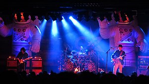 Primus performing in 2014. Left to right: Larry "Ler" LaLonde, Tim "Herb" Alexander, and Les Claypool
