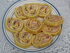 Sliced Savory Argentine pionono, with Ham, cheese, Salsa golf and vegetables