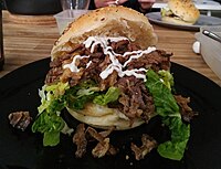 Shredded beef in a bun with lettuce and mayonnaise
