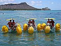 Human powered aqua-cycle water trikes in the Pacific Ocean with Diamond Head, Hawaii in the background.