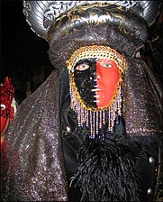 Exotic masquerader in beads, feathers, headdress, and face paint (2004)