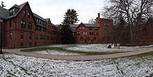A panorama of the courtyard and winged sides of a three- and four-story brick dormitory