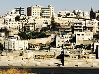 Member of the ultra-Orthodox Jewish community walking in front of Silwan. Many members of the ultra-Orthodox community travel to and live in Jerusalem