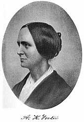 Photographie noir et blanc de profil, en médaillon, d'une femme avec un chignon noir, un foulard blanc autour du cou