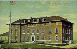 A color postcard depicting a three-story brick building