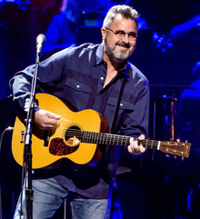 Musician Vince Gill playing an acoustic guitar