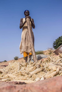 A woman threshing sorghum In Northern Ghana, 2021