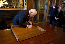 Dick Cheney signing the inside of a desk drawer