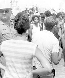 Black and white photograph of segregationists, highway patrol and black demonstrators at a "white only" beach