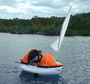 Proactive lifeboat, sailing. Note unzipped middle section of canopy and reefed sail.