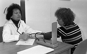 בדיקת לחץ דם בירושלים, בשנות השבעים. מטופלת יושבת עם אחות לבדיקה