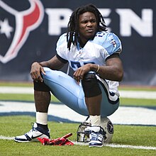 Chris Johnson in a Tennessee Titans uniform sitting on his helmet.