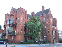 A large red brick building with steep slate covered roofs