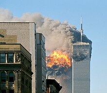 The twin towers are seen spewing black smoke and flames, particularly from the left of the two