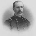 Black and white print of a man with a receding hairline and a drooping moustache wearing a dark uniform with two rows of buttons.