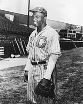 A black man in baseball uniform with the letters "K" and "C" on the chest