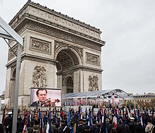 A crowd is around the Arc of Triumph in Paris, France.