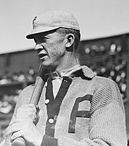 Photograph of Phillies pitcher Grover Cleveland Alexander, resting a bat on his right shoulder, taken from his left side