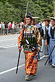 京都の時代祭において復元された中世の腹当を着用して通りを歩く男性