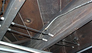 Wiring running through tubes, and turning a corner supported by a knob. Notice the direct splice with more modern (1950s-era) non-metallic–sheathed cable. This type of connection is forbidden by the National Electrical Code, and a junction box should have been used.